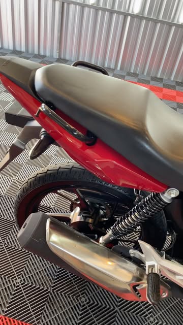 Roda traseira e escapamento de moto na oficina