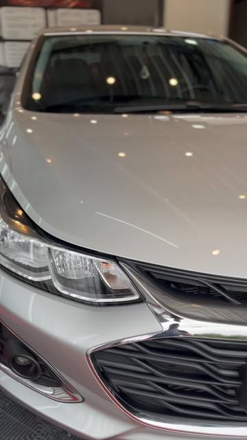 Chevrolet Cruze prata com acabamento polido na frente do veículo